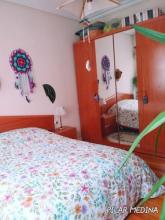 Habitacion exterior con mucha luz, cama de matrimonio dos mesillas y armario ropero